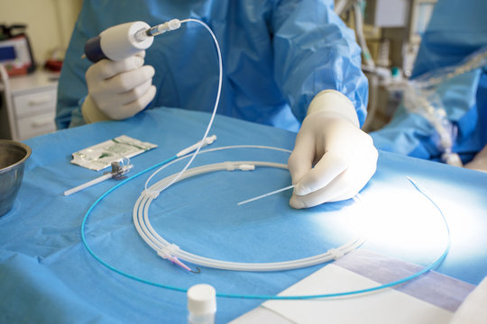 Doctor preparing instrument for vein surgery