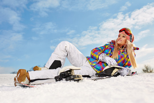 Sport girl with snowboard high in the winter snowy mountains. At