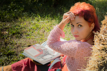 Portrait of hipster woman with pink curly hair. Beautiful hippie with red hair