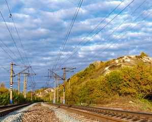 Railway near a mountain. Dense clouds in the sky.