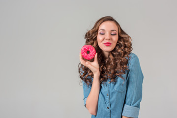 The smiling girl on gray studio background with round cake