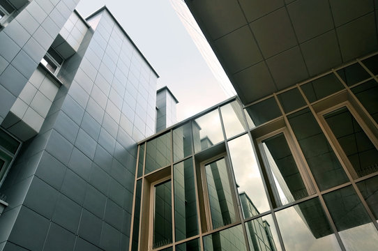 Look up at the modern facade of glass and wall panels.