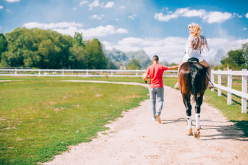 Fototapeta premium couple and horse at a farm ridding and kissing each other.