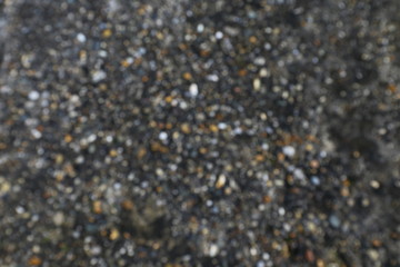 Hintergrund, kleine Kiesel in dunklem Boden