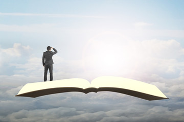 Man standing and gazing on book flying in sky