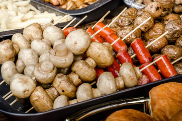 Porcini mushrooms grilled mushrooms on skewers. Street festival food.