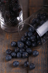 Glasses of glass with blueberries and blackberries on wooden background