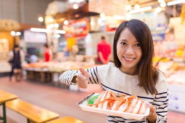 Woman holding snow crab and showing thumb up © leungchopan