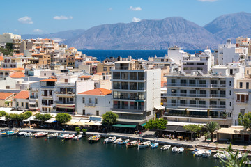 View of buildings, mountains, and sea in the coastal city of Agios Nikolaos in Crete