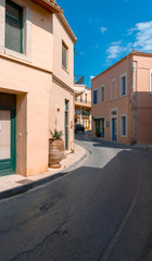 Fototapeta na wymiar Pink buildings and road in Crete village