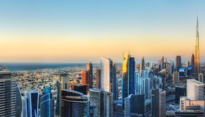 Fototapeta na wymiar Fantastic aerial view over a big modern city with skyscrapers. Downtown Dubai, United Arab Emirates. Colorful futuristic cityscape.