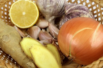 Natural treatment. Closeup of a wicker basket garlic, ginger, lemon, onion. Natural medicine for flu, bronchitis and colds. 