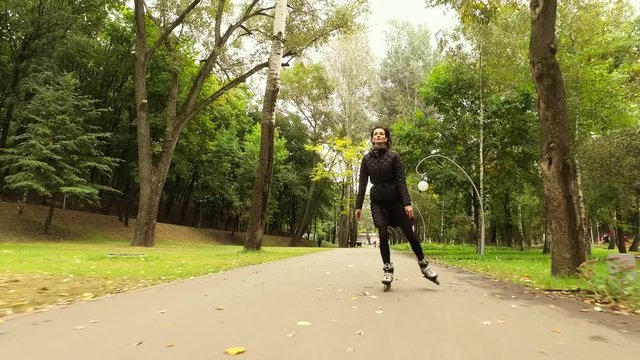 Inline skates. Dark-haired stylish woman moving on roller skates. Female skater practicing inline skating. 4K