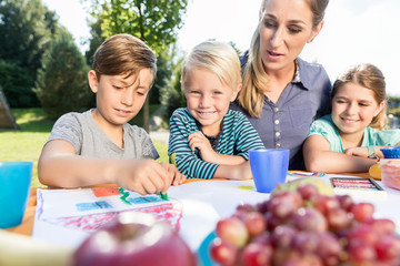 Mutter malt mit ihren Kindern während der Mittagspause