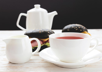 Fototapeta premium Black Hamburger , cup of tea and milk for breakfast.