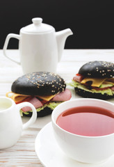 Black Hamburger , cup of tea and milk for breakfast.