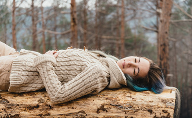 Woman lying on tree trunk