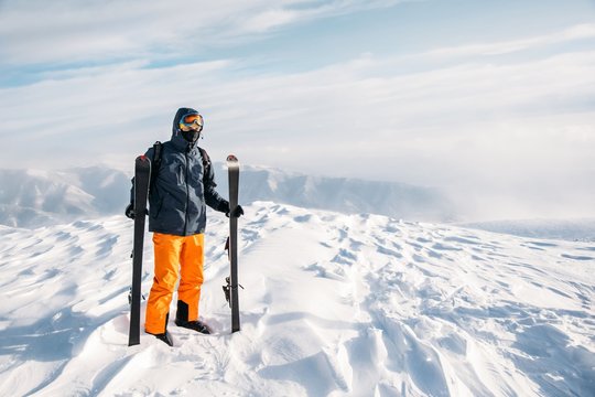 Skier standing on snowy mountain summit 