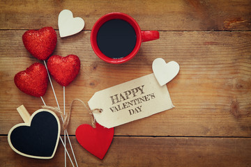 Red hearts and cup of coffee on wooden background