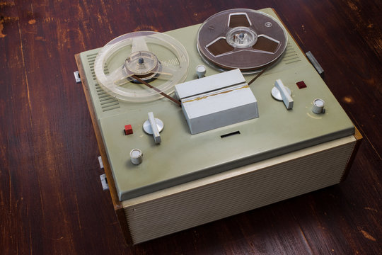 Vintage soviet magnetic audio tape reel-to-reel recorder on old red wooden table