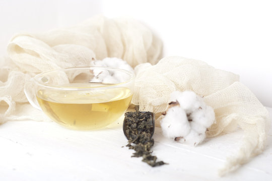 green tea and cotton on white wooden table