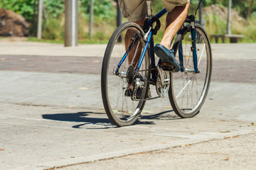 Fototapeta na wymiar Man's legs cycling down the street