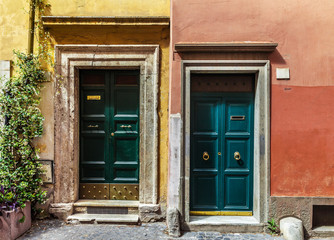 Fototapeta na wymiar Two classic Italian doors on walls painted blue and orange