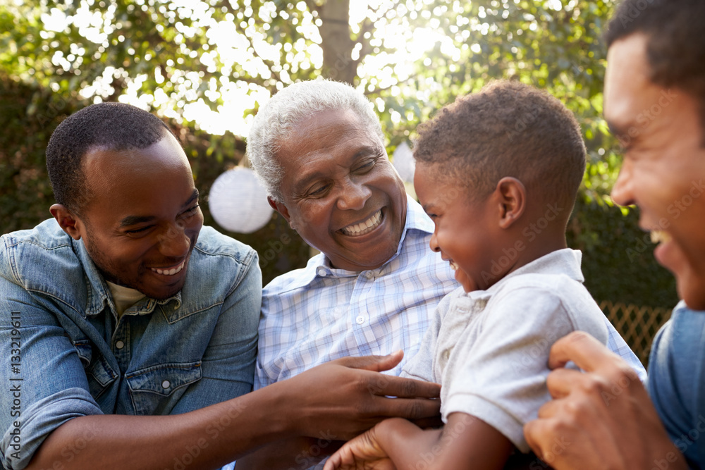 Wall mural black grandfather, sons and grandson talking in a garden