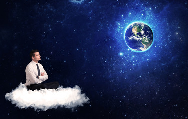 Obraz na płótnie Canvas Man sitting on cloud looking at planet earth