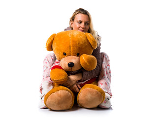 Pretty blonde girl in cute pajamas with big stuffed animal