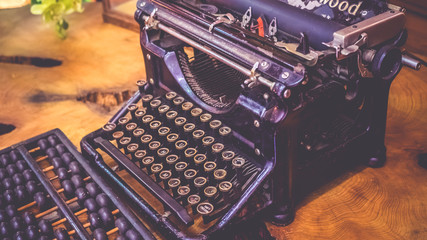 Old rusty typewriter and wooden abacus. (vintage style)