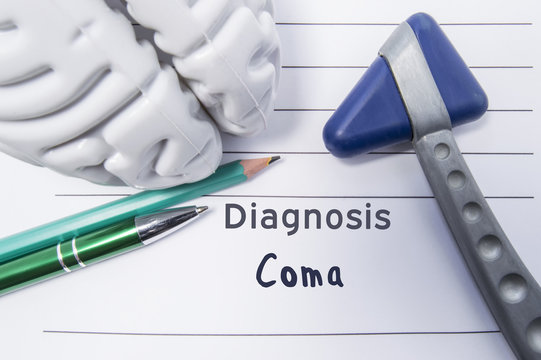 Neurological diagnosis of Coma. Neurological reflex hammer, shape of the brain, pen and pencil the lying on a medical report, labeled with diagnosis of Coma. Concept for neurology