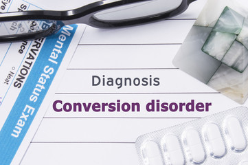 Diagnosis Conversion disorder. Medical notebook labeled Diagnosis Conversion disorder, psychiatric mental questionnaire and pills are on table in psychiatrist cabinet or counselor of this problem