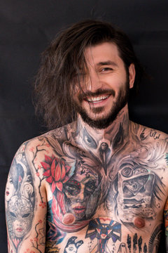 Tattooed naked man with messy wet hair laughing