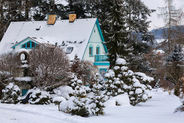 beautiful house in winter garden covered by snow