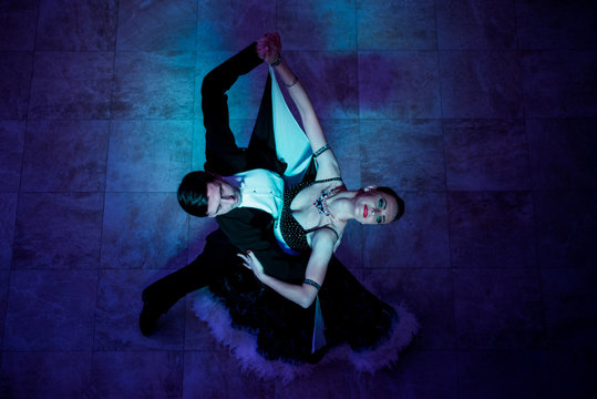 Latino dancers in ballroom  on black background