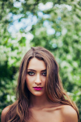 Naklejka premium Portrait of young beautiful woman posing among spring blossom trees.