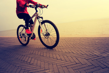 one young woman riding bike on seaside