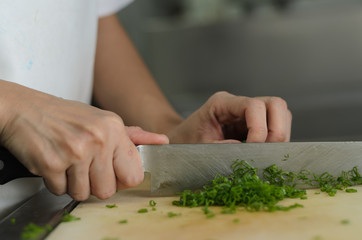 Chef training cut vegetable on cutting board with knife japan