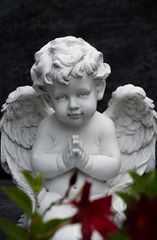 kleine betende engelsfigur auf einem grab