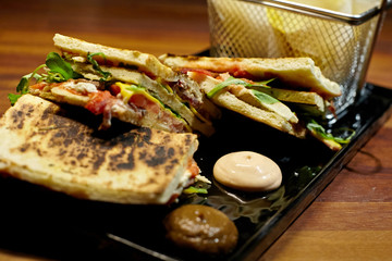 Club sandwich with fresh bread and potatoes.