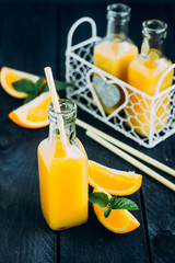 Fresh Orange juice in bottle on blue table background. Summer drink concept