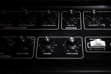 Vintage analogue synth control panel closeup in shallow focus