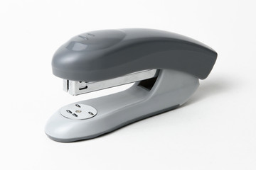 Closeup of a grey office stapler, isolated on white background