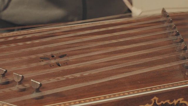 Someone is playing the ethnic musical instrument - santur