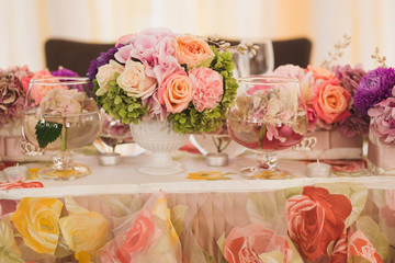 Table setting at wedding reception. Wedding floral decorations on the newlyweds' table.