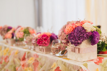 Table setting at wedding reception. Wedding floral decorations on the newlyweds' table.