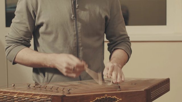 Man is playing the ethnic musical instrument - santur