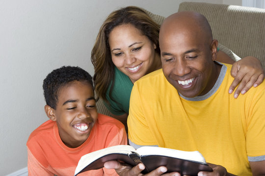 African American multicultural family reading The Bible.