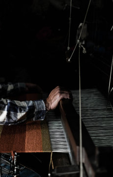 Ein Weber webt am Webstuhl einen Teppisch aus Wolle; Kunsthandwerk